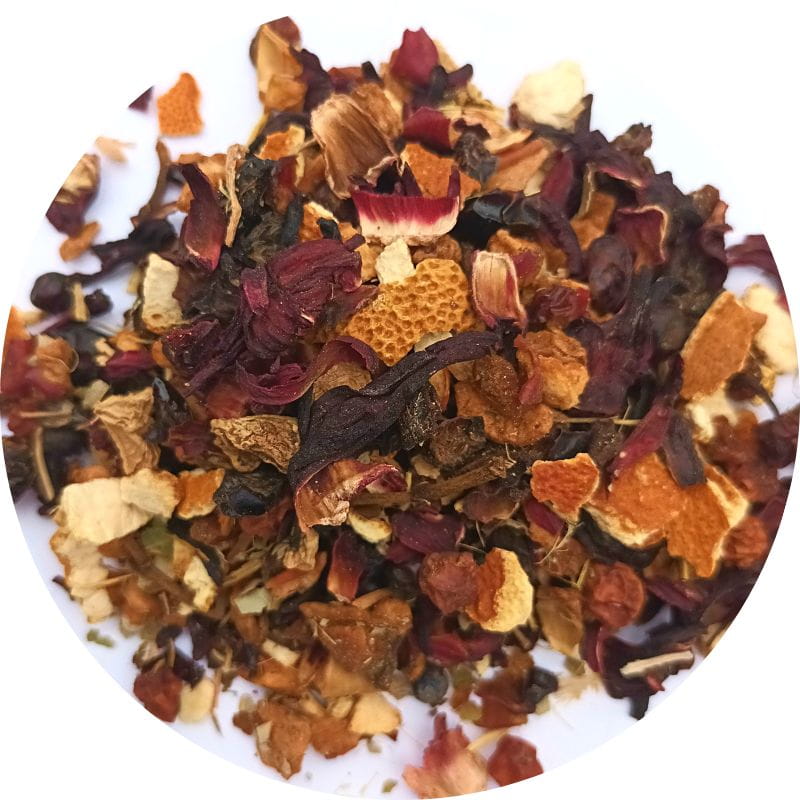 Mélange de la Tisane de Noël Épicée de MerveilleNature, composé de pomme, cynorrhodon, raisins secs, hibiscus, écorce d’orange, réglisse, clous de girofle et gingembre, prêt à infuser pour une boisson chaude festive.