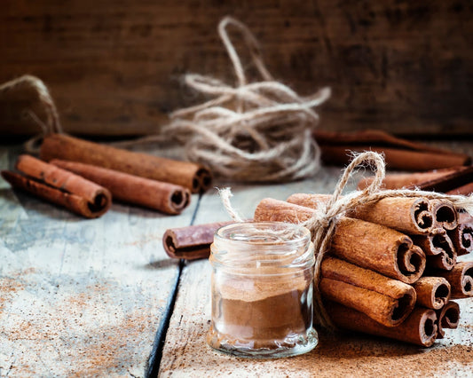 Bâtons de cannelle entiers et poudre de cannelle de Ceylan dans un pot en verre, sur une table en bois, pour cuisine et infusions digestives