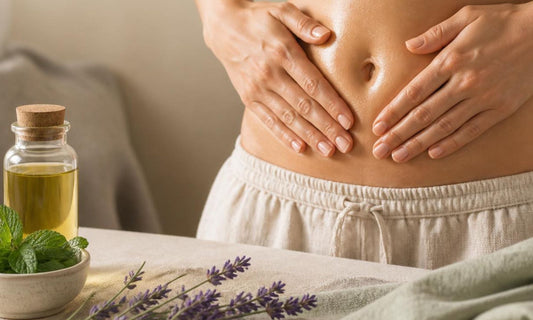 Femme pratiquant un doux massage du ventre avec une huile aux huiles essentielles de menthe poivrée et lavande vraie