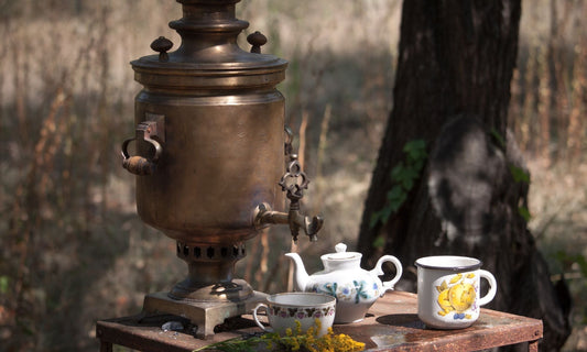Samovar en cuivre pour infusion d’Ivan Chaï, thé russe traditionnel, avec théière en porcelaine et tasse artisanale, posé sur une table en bois en forêt. Scène authentique de préparation du thé d’épilobe