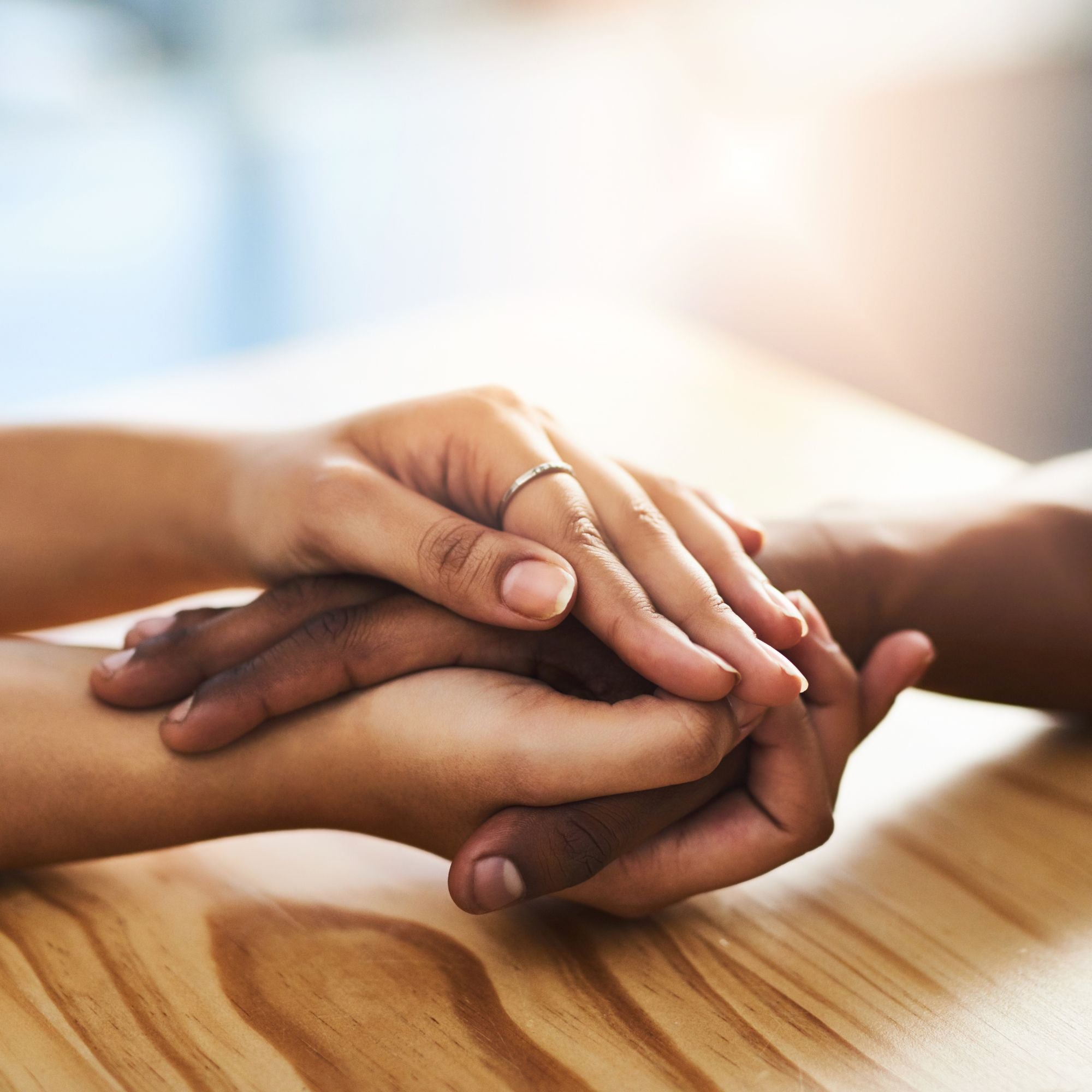 Deux mains tenant une autre main en signe de soutien et de bienveillance