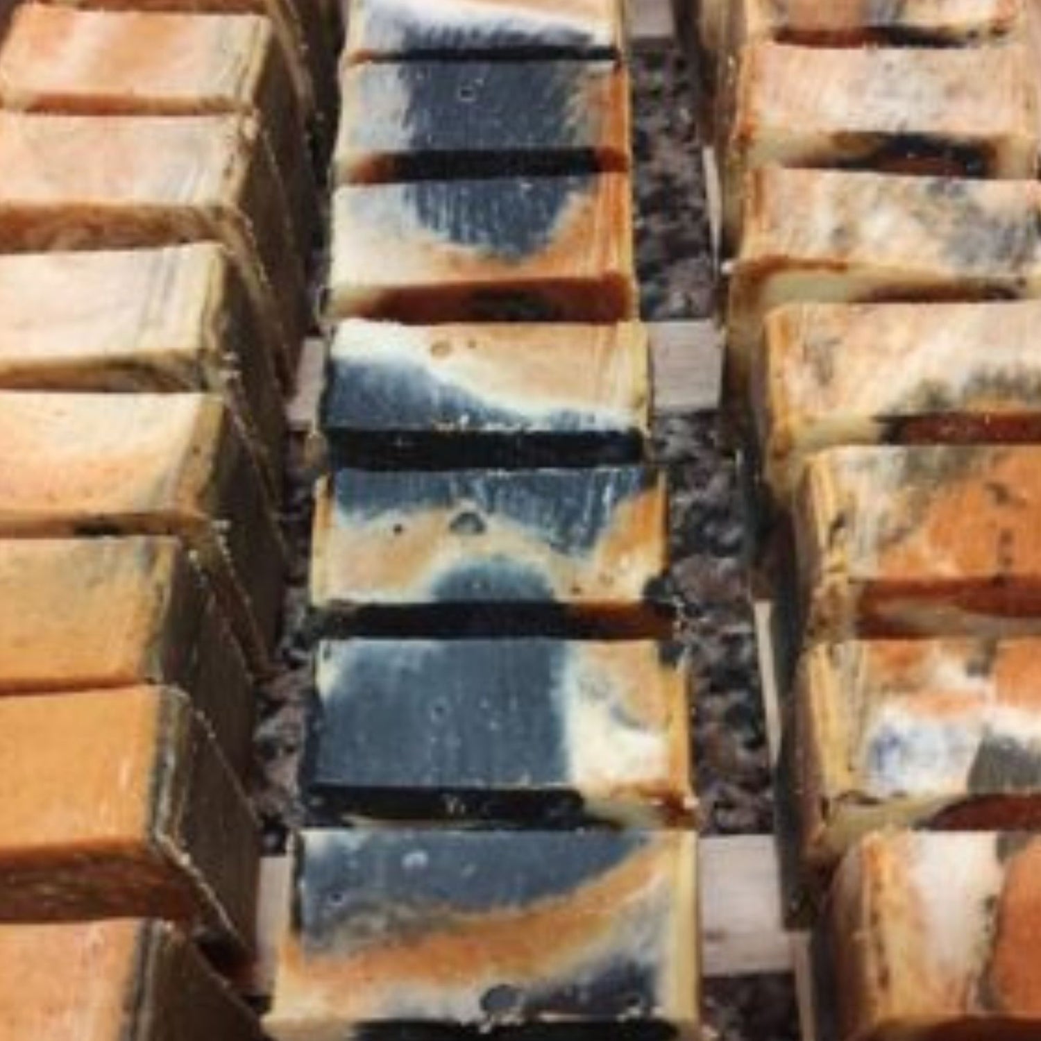 Fabrication de savons bio KAEA avec trois rangées de savons artisanaux en cours de séchage