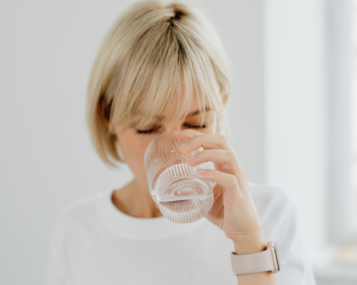 Femme buvant un verre d’eau au collagène, boisson fonctionnelle pour soutenir la santé de la peau, des articulations et du bien-être général du corps
