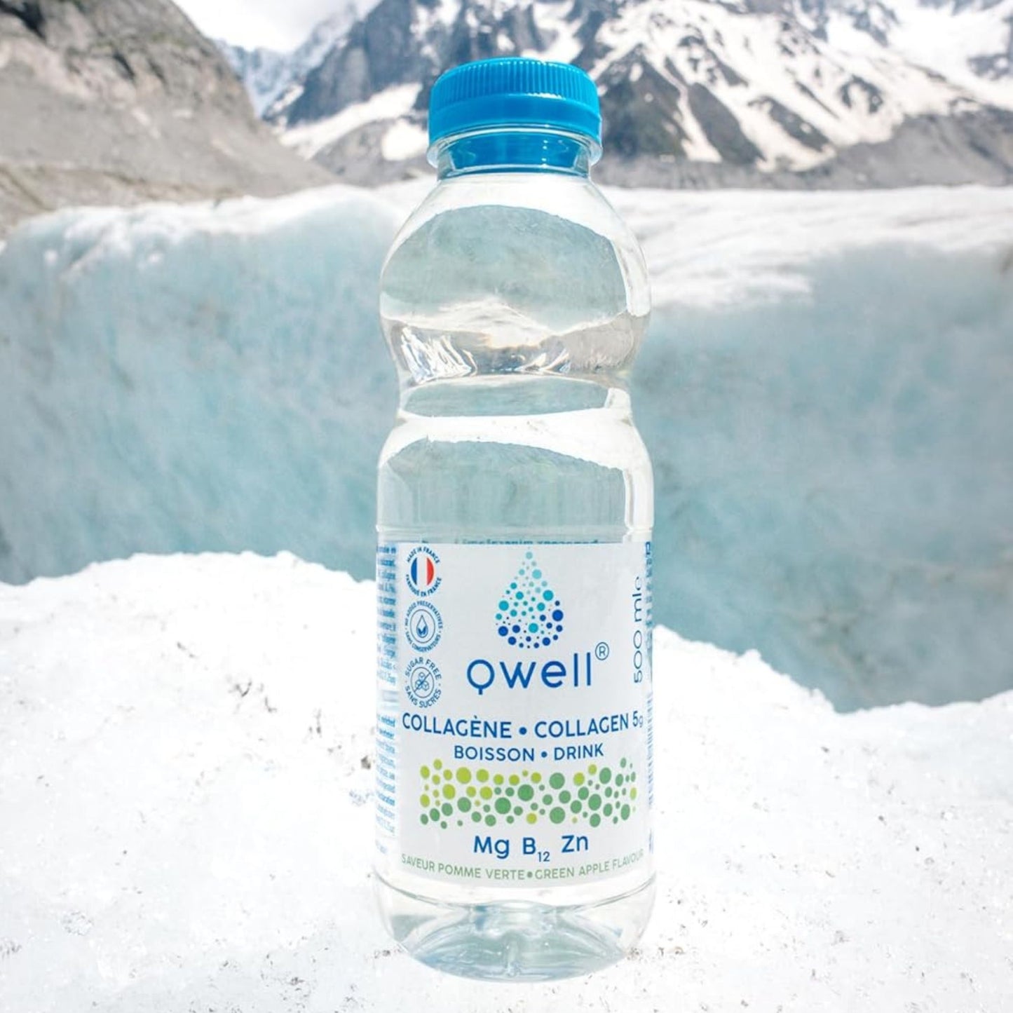 Bouteille Qwell collagène saveur pomme verte avec magnésium, vitamine B12 et zinc, posée sur de la neige devant un glacier de montagne, évoquant performance sportive et récupération naturelle